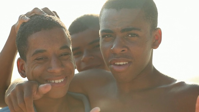 3个有色人种的男孩在海滩上视频下载