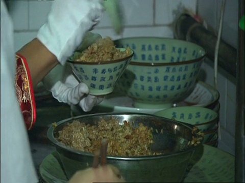 中国北京，用勺子把米饭盛进小碗里视频素材