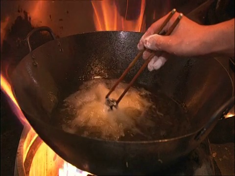 中国北京，将鱼放入滚烫的油锅中视频素材