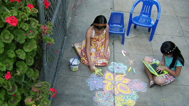 两个小女孩在操场上玩，用粉笔和笔记本画画/洛杉矶，加利福尼亚，美国视频素材