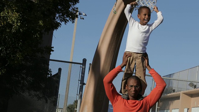 一个非裔美国男孩站在父亲的肩膀上视频素材