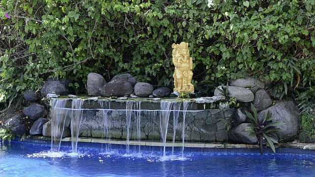 酒店游泳池，小瀑布和雕像在亚洲/坎迪，达萨巴厘岛，印度尼西亚视频素材