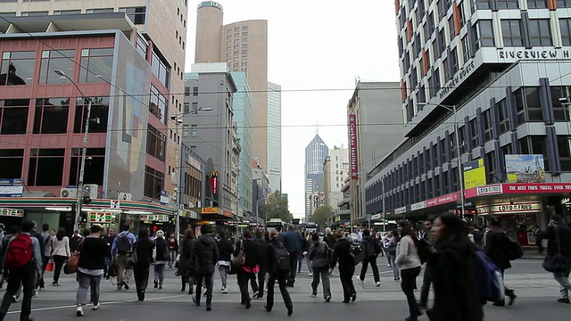 在澳大利亚维多利亚州墨尔本的弗林德斯街车站，拥挤的行人穿过繁忙的城市街道视频下载