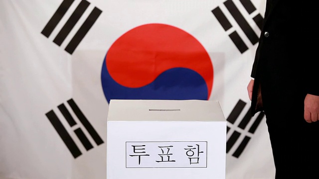 韩国首尔，在韩国国旗前将选票插入韩语票箱视频素材