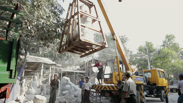 一尊完整的佛像被起重机吊到一辆卡车上，缅甸曼德勒视频素材