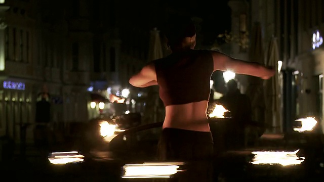 德国萨克森，德累斯顿，晚上，女火舞者在街道上跳着燃烧的呼啦圈视频素材