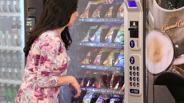 女士在美国弗吉尼亚州里士满自助餐厅的自动售货机购买零食视频下载