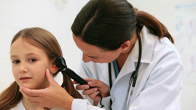 全科医生用耳镜听诊病人的耳朵视频素材