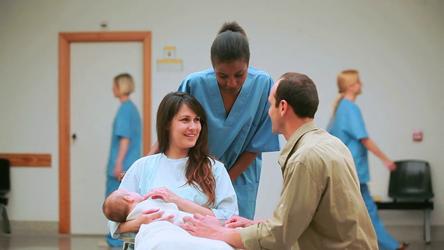 微笑的护士在微笑的母亲和带着孩子的父亲后面视频下载