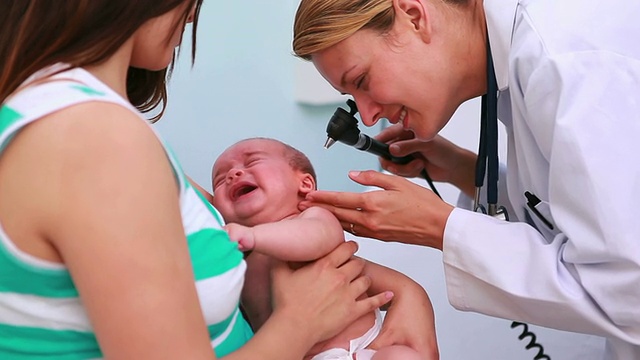 医生在母亲怀里用耳镜检查婴儿视频素材
