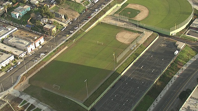 中远镜头空中跟踪-左放大-篮球场旁边的棒球场，和一个足球场，在一个户外体育中心。/美国加州洛杉矶视频素材