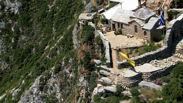 希腊，马其顿，阿陀斯山，空中的一位僧人在阿陀斯山南端的修道院挥舞着黄色的旗帜视频下载