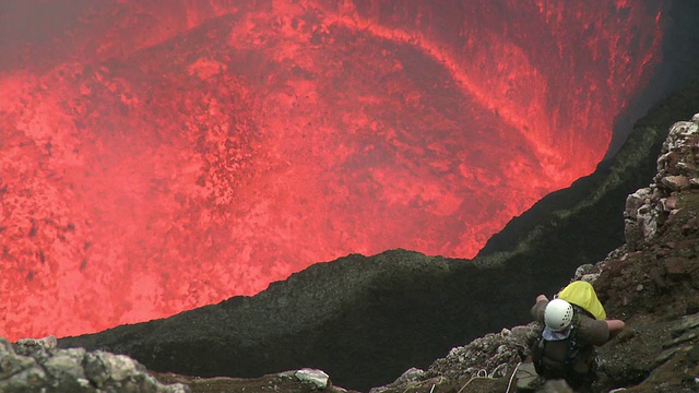 瓦努阿图安布里姆岛马鲁姆火山，一名登山者站在喷发的危险熔岩之上视频素材
