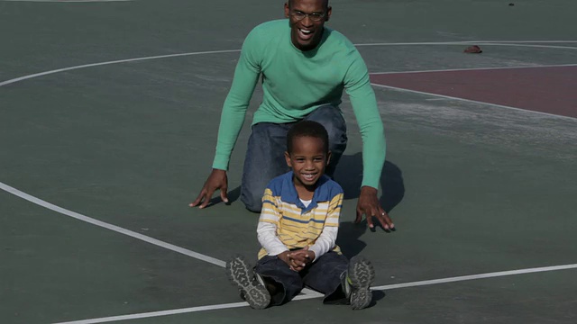 非裔美国人父亲和儿子在篮球场上视频素材