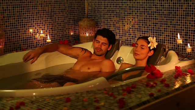 好看的年轻夫妇放松在按摩浴缸视频素材