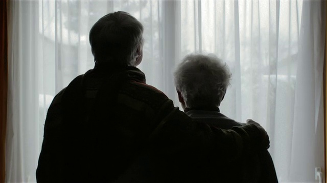 一对老夫妇站在窗前视频素材