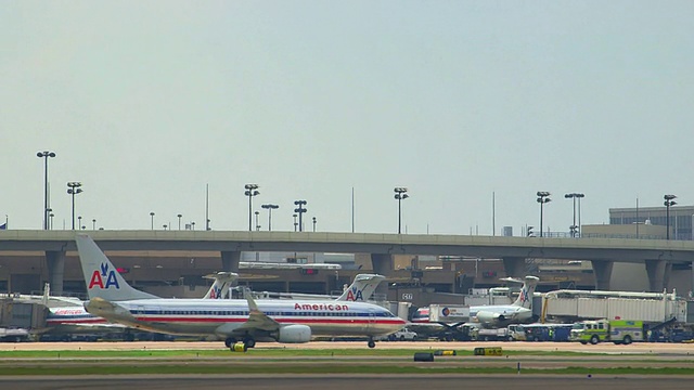 泛美鹰(Embrear ERJ)通勤飞机(Embrear ERJ)起飞，背景是机场航站楼和塔台/美国德克萨斯州达拉斯沃斯堡国际机场视频素材