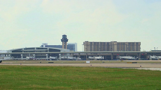 PAN Delta喷气式飞机起飞，背景是机场航站楼和塔台/美国德克萨斯州达拉斯沃斯堡国际机场视频素材