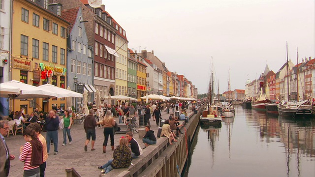 中远镜头静态-游客步行在一个风景优美的运河附近。丹麦哥本哈根/视频下载