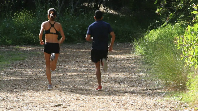 两名跑步者穿越森林/美国加州洛杉矶视频素材