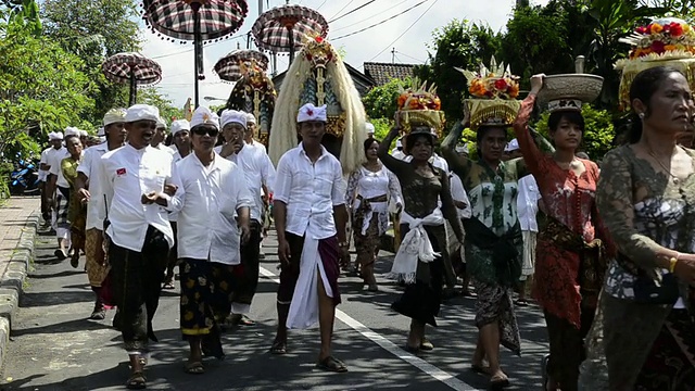 在印尼巴厘岛的乌布，妇女们头上顶着祭品和巴龙塑像视频下载