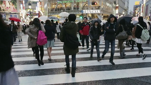 在日本东京涩谷区，人群穿过十字路口或争抢人行道视频下载