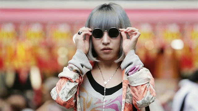日本东京原宿区，一名时尚女孩戴着墨镜在竹下街前摆姿势视频素材