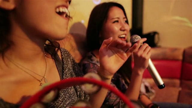 在日本东京的卡拉ok俱乐部里，CU的女孩们一边唱歌一边摇手鼓视频下载