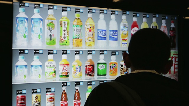 日本东京，一名男子在一台超现代的自动售货机上购买饮料视频下载