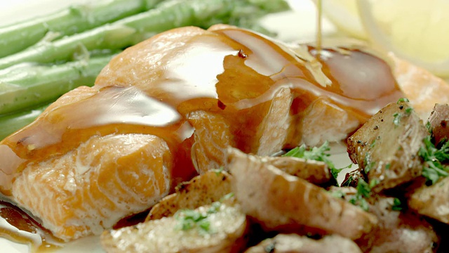 配芦笋和土豆的正餐盘上的三文鱼排淋上红烧酱汁视频下载