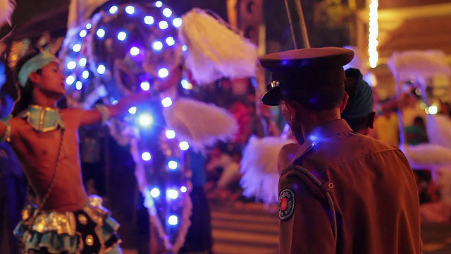 在佛教节或“Esala Perahera”(牙齿节)游行中，MS警察站在舞者和大象前面视频素材