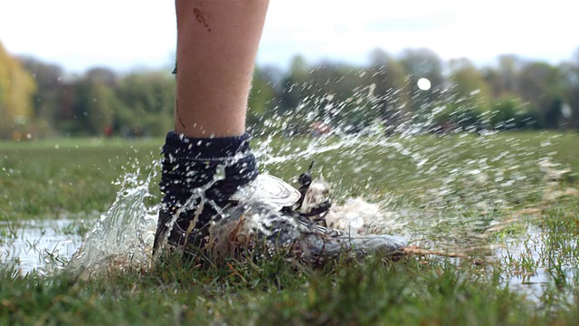 CU SLO MO足球靴穿过水坑/英国曼彻斯特视频下载