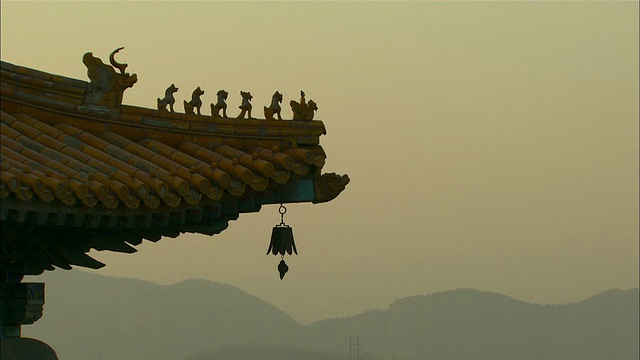 远射泛左-小雕像装饰的塔顶在朦胧的天空。中国/北京视频素材