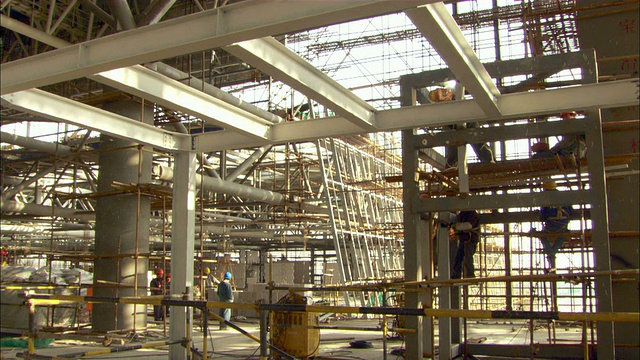 靠近泛左放大-焊接工在一个在建的火车站的金属框架上工作。/上海,中国视频下载