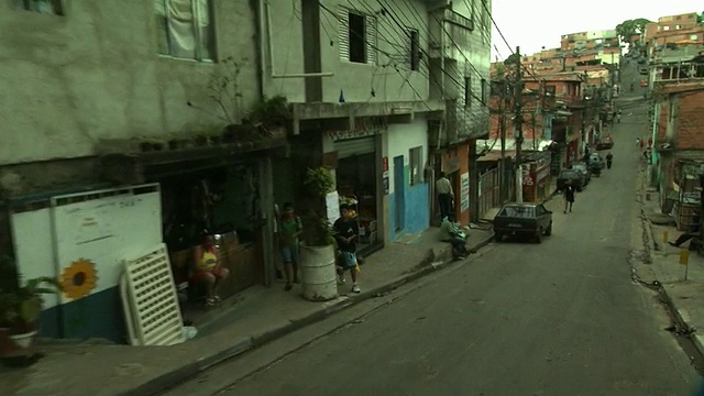 中远镜头推入-行人走在圣保罗贫民窟的街道上。/巴西圣保罗视频下载