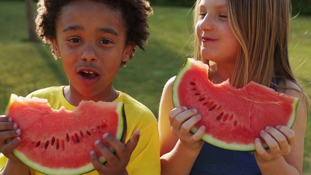 两个孩子在公园吃西瓜的慢镜头视频下载
