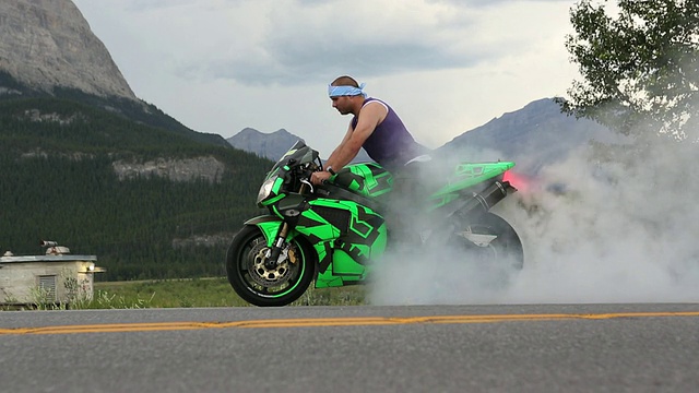 男子骑摩托车在山路上表演特技视频下载