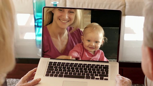 老两口和女儿、孙子在网上享受视频。视频下载