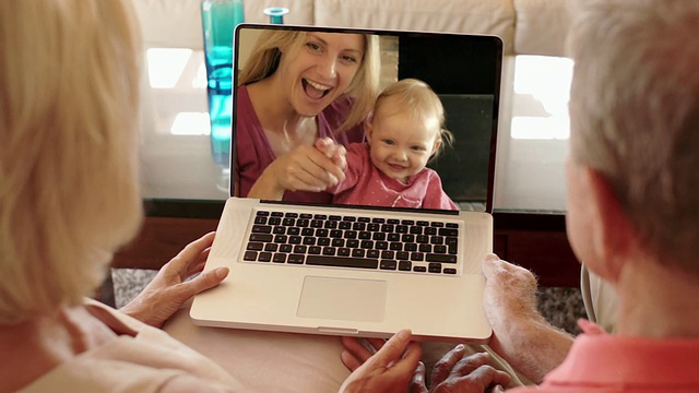 老两口和女儿、孙子在网上享受视频。视频下载