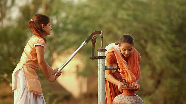 印度哈里亚纳邦法里达巴德，两个女孩正在用手抽水视频素材