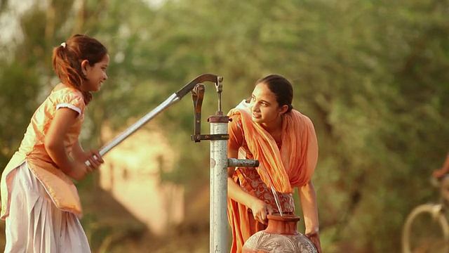 印度哈里亚纳邦法里达巴德，两个女孩正在用手抽水视频素材