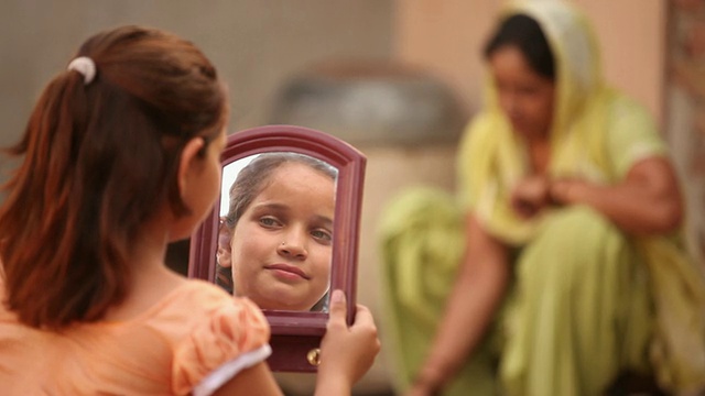 印度哈里亚纳邦法里达巴德，女孩在镜子里看着自己的脸视频素材