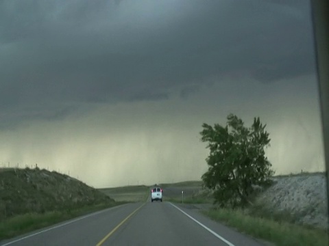 闪电击中前方的货车行驶在道路上，风暴追逐者接近雷暴，美国西澳视频下载