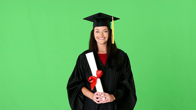 年轻女子毕业在长袍与文凭视频素材