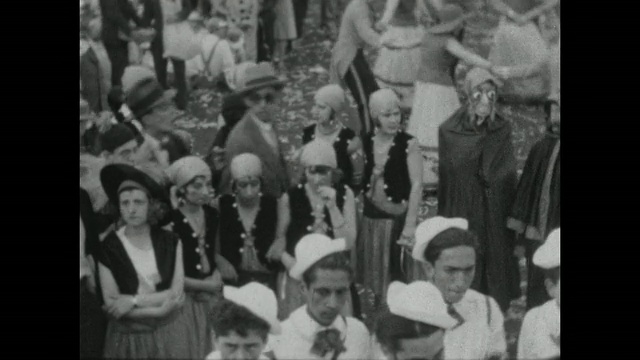 1927年，布宜诺斯艾利斯狂欢节上，一群穿着复古服装的人们等待着游行。一名戴面具的男子向镜头鞠躬。视频素材
