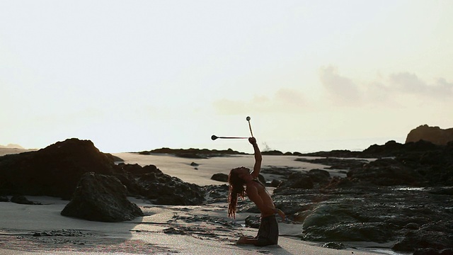 MS Rasta man在海滩上练习瑜伽姿势，同时旋转poi球/蒙特祖玛，Punteranes，哥斯达黎加视频素材