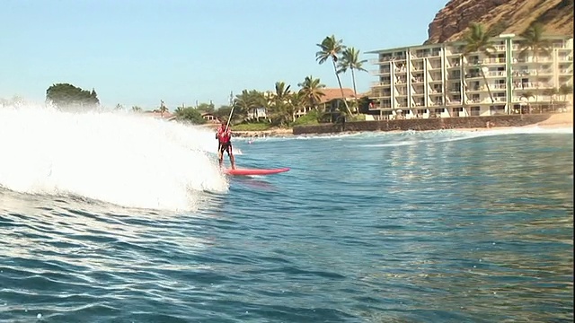长镜头手持跟踪右放大-冲浪者骑着海浪走向海岸。美国夏威夷/视频下载