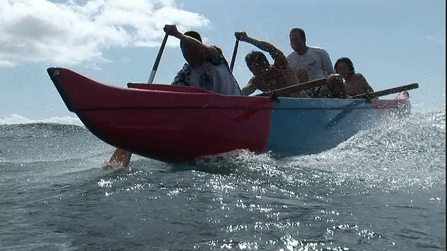 长镜头手持式泛左-男子划着双体船在夏威夷的波浪上。美国夏威夷/视频素材