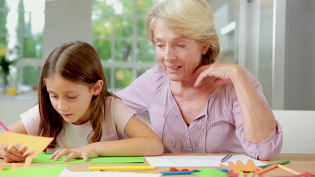 一个孩子一边画一边跟奶奶说话视频素材