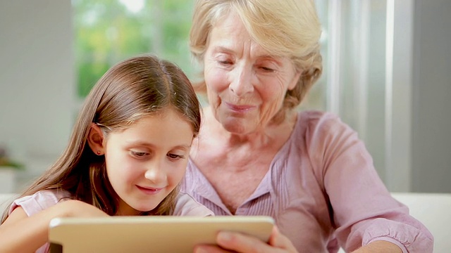 孩子和奶奶一起使用平板电脑视频素材